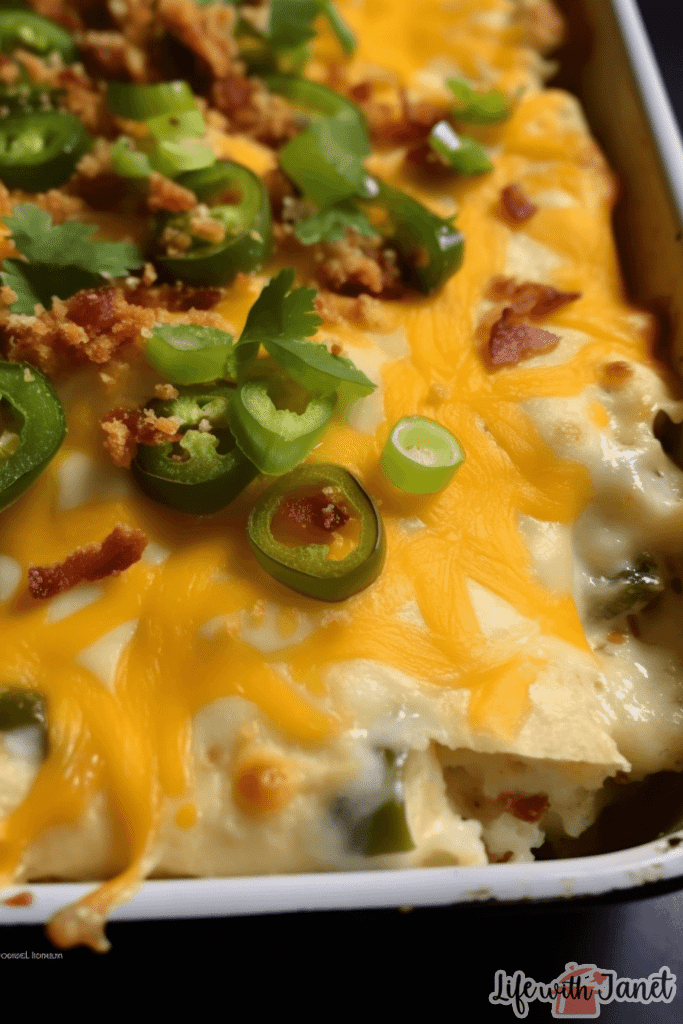 Golden-browned Jalapeno Popper Chicken Casserole in a ceramic dish, topped with melted cheese and freshly chopped jalapenos.