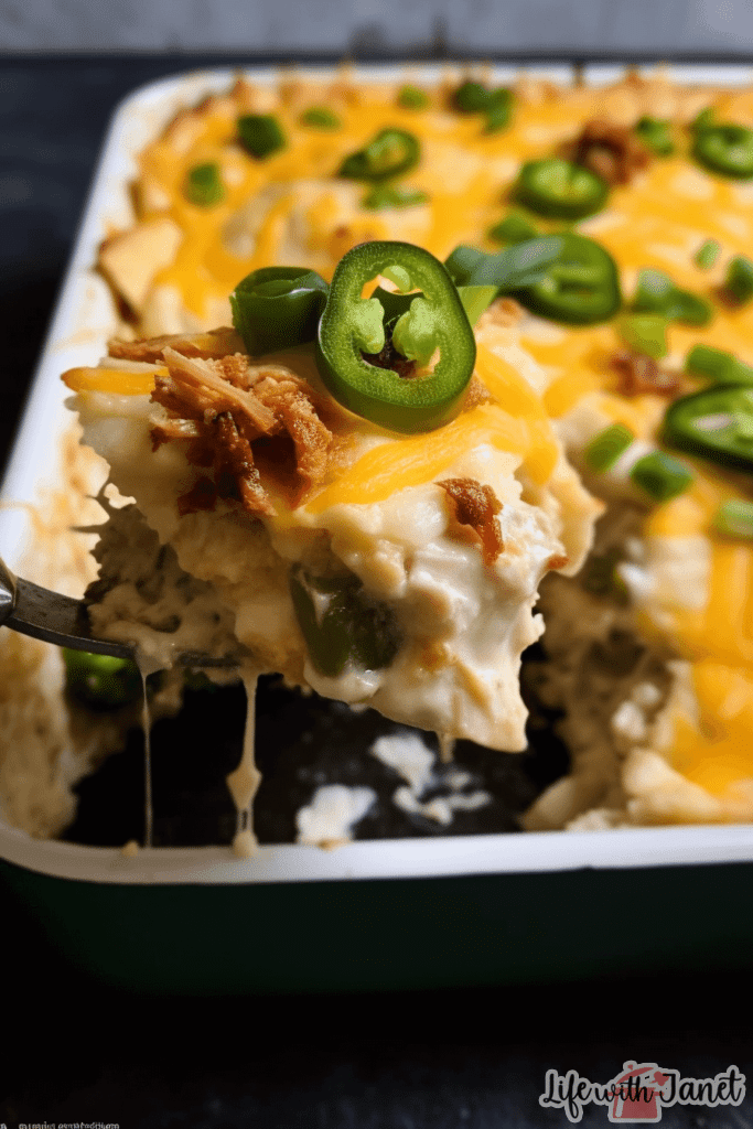 A plate served with a generous slice of Jalapeno Popper Chicken Casserole, accompanied by a side salad and a dollop of sour cream.