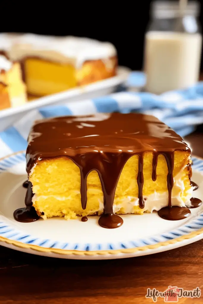 Golden-yellow Boston Cream Poke Cake topped with a glossy chocolate ganache and filled with creamy vanilla pudding.