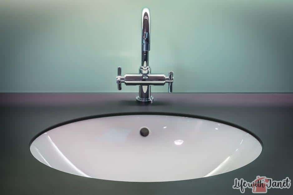 A person washing their hands in the kitchen sink